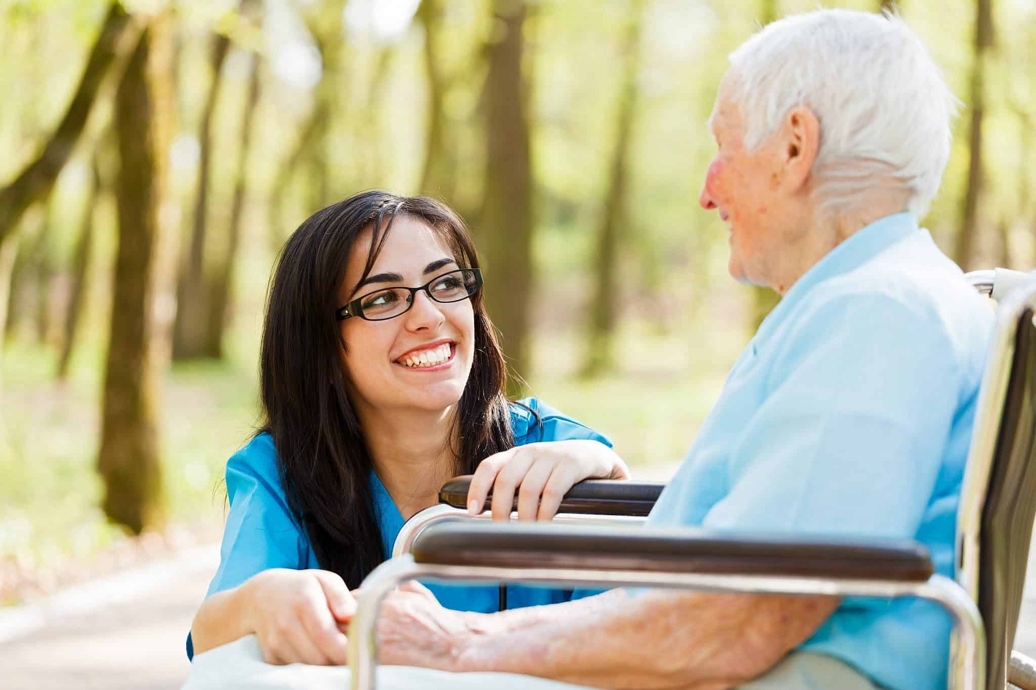 Caregiver and client laughing outdoors