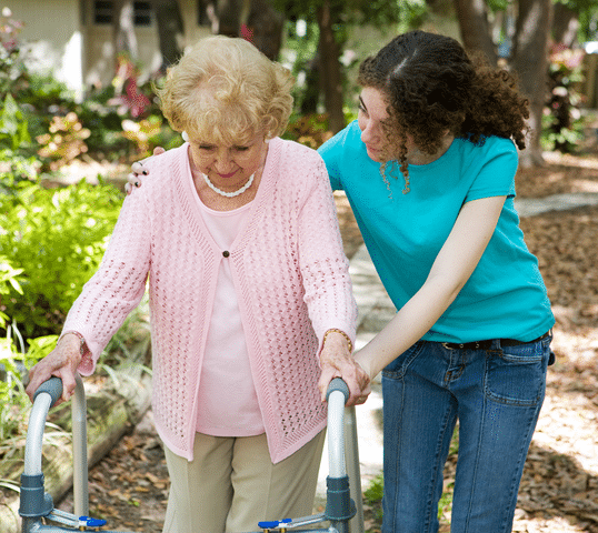 Woman outside with caregiver assisting